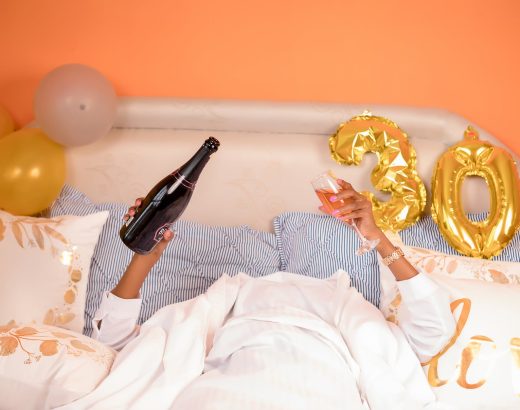 woman lying down in bed with champagne