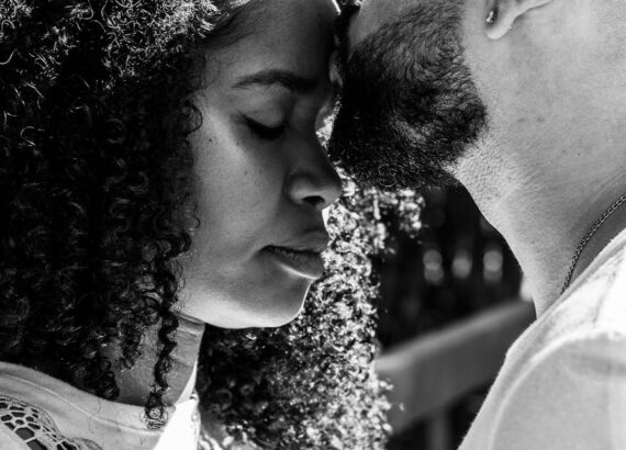a man kissing a woman s forehead