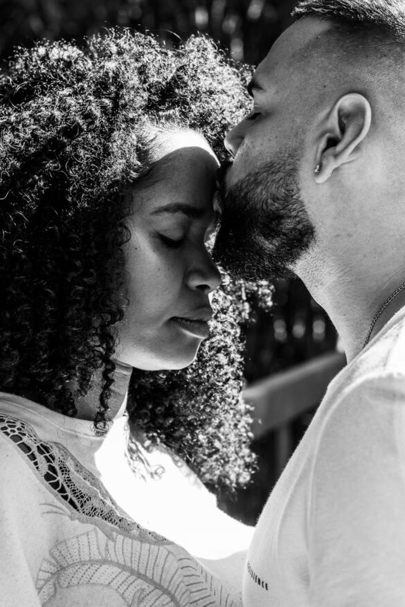 a man kissing a woman s forehead