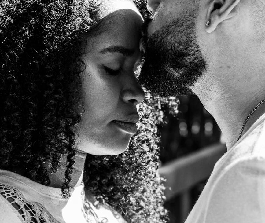 a man kissing a woman s forehead